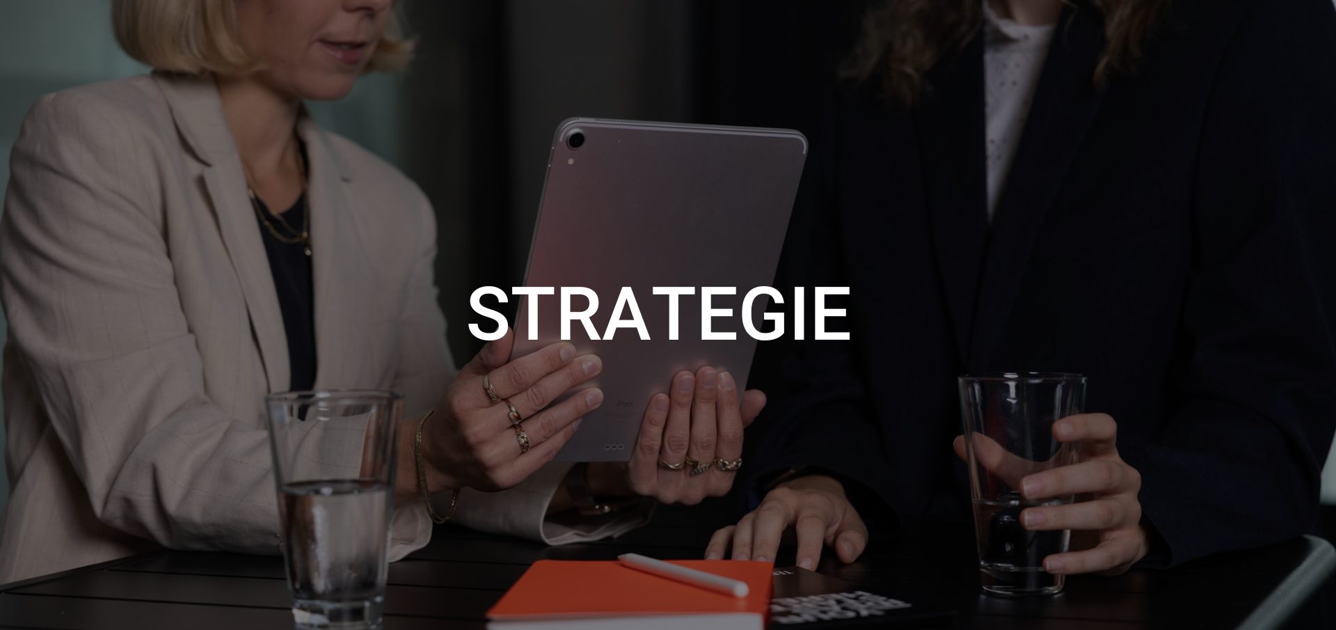 Gemeinsame Strategieentwicklung: Zwei Mitarbeitende analysieren Medienkanäle und planen eine crossmediale Mediastrategie.